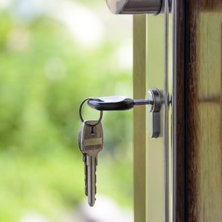 Una chiave infilata nella serratura di una porta aperta