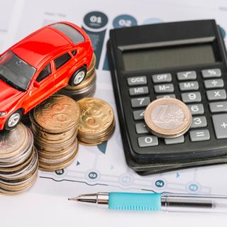 auto con calcolatrice e soldi