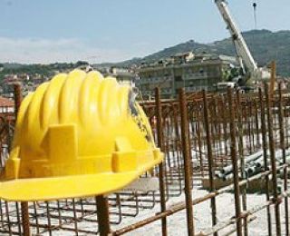 Cantieri fermi, con casco da operaio abbandonato in primo piano