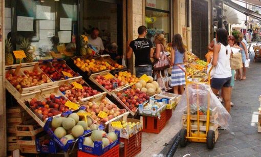 negozio di vicinato con clienti e cassette