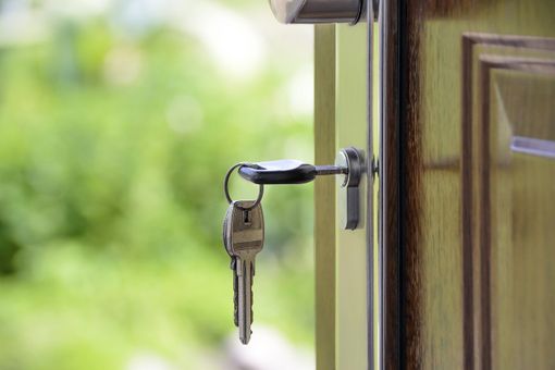 Una chiave infilata nella serratura di una porta aperta