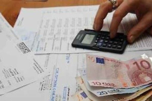 persona che fa calcoli con delle bollette sul tavolo
