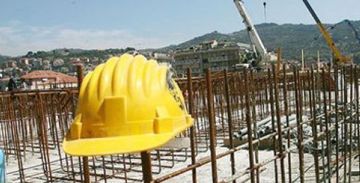 Cantieri fermi, con casco da operaio abbandonato in primo piano
