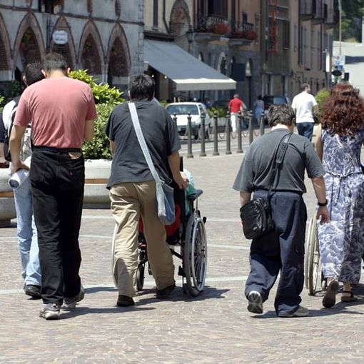 Persone in carrozzina con accompagnatori