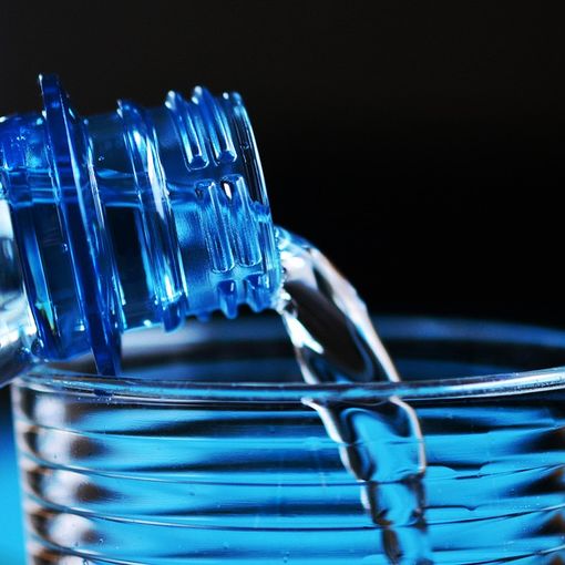 bottiglia con acqua in un bicchiere
