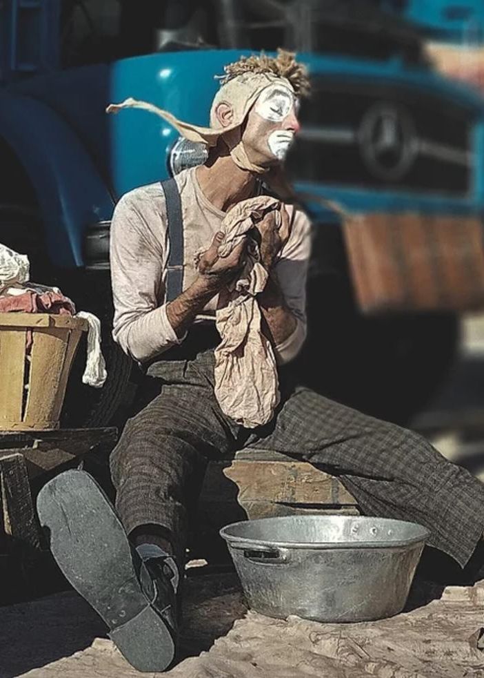 Spettacolo di circo contemporaneo con artista seduto per terra