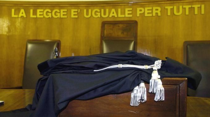 aula di tribunale con toga e scritta