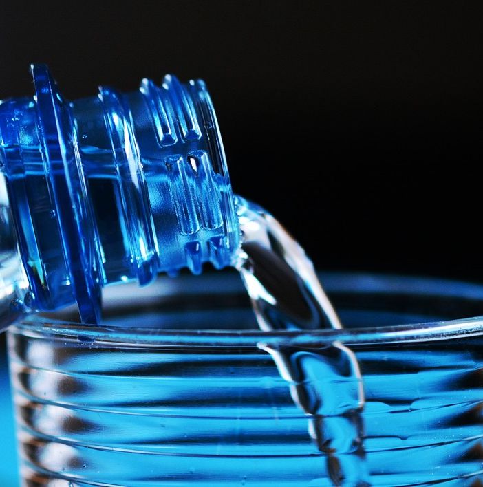 bottiglia con acqua in un bicchiere