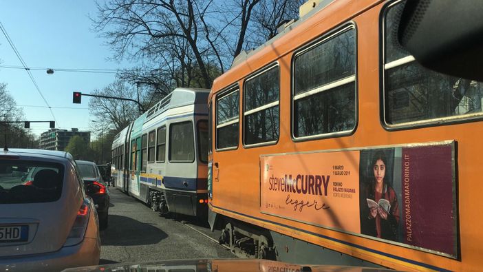 tram vecchi e nuovi lungo una strada di Torino