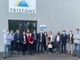Delegazione in visita di fronte a un'azienda