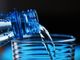 bottiglia con acqua in un bicchiere