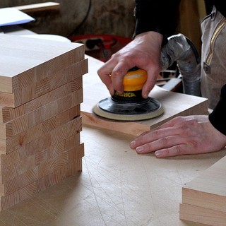 artigiano che lavora il legno con una pialla