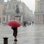Persona con ombrello in piazza San Carlo